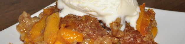Crock Pot Slow Cooker Peach Cobbler topped with vanilla icecream