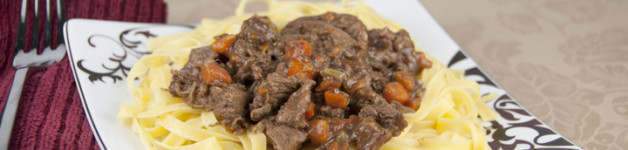 Old Fashioned Beef Stew Recipe served over buttered egg noodles
