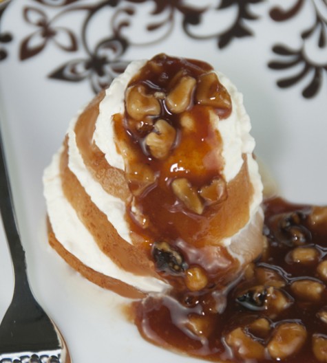 A simple recipe for poached pears in orange juice and topped with cinnamon syrup and walnuts.