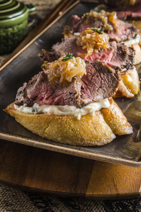 Holiday Steak Bruschetta made with beef loin, baguette, and a seasonal thyme mayonnaisse with caramelized onions . Great Thanksgiving or Christmas day appetizer.
