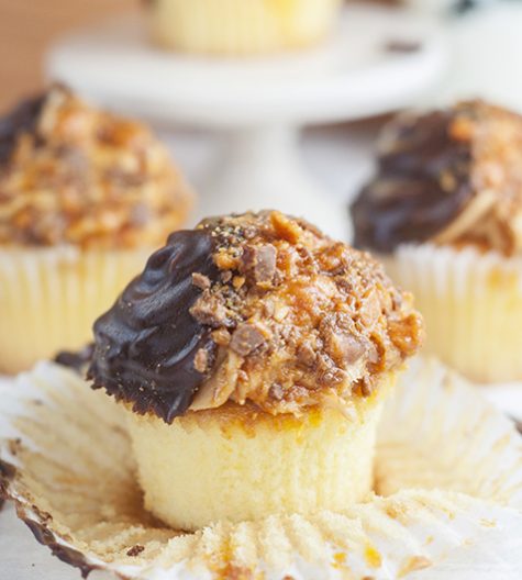 The ultimate soft and fluffy Vanilla Butterfinger Cupcakes are loaded with flavor and the perfect dessert recipe for the candy and peanut butter lover in your life!
