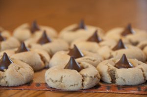 Peanut butter and chocolate come together in this perfect, classic Peanut Butter Blossoms recipe. They are so easy to make and a tradition for every Christmas holiday!