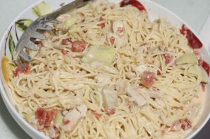 This Creamy vegetarian dish has spaghetti with artichoke hearts and tomatoes that is a super easy recipe to make!