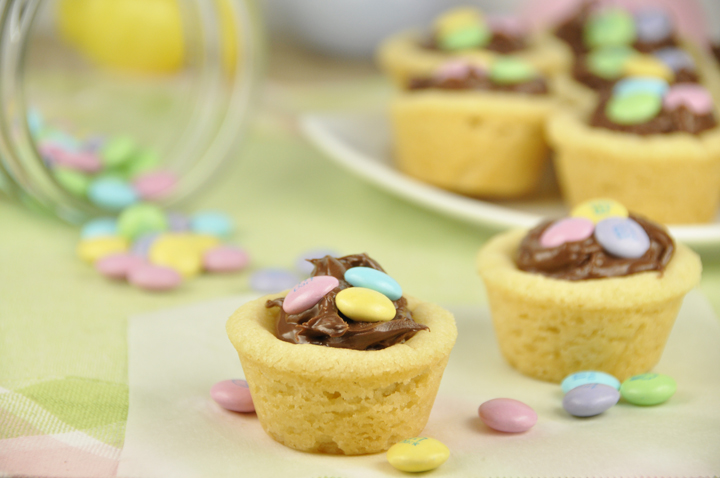 Easy, colorful and delicious M&M Nutella cookie cups are sugar cookie cups filled with Nutella and topped with dark chocolate M&M's. This is a great idea for Easter dessert or spring dessert to take to a party!