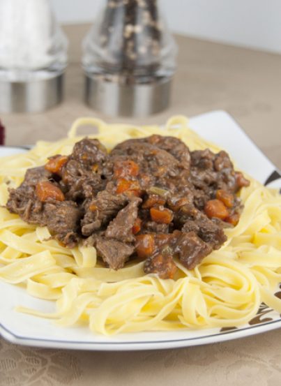 Old Fashioned Beef Stew Recipe served over buttered egg noodles