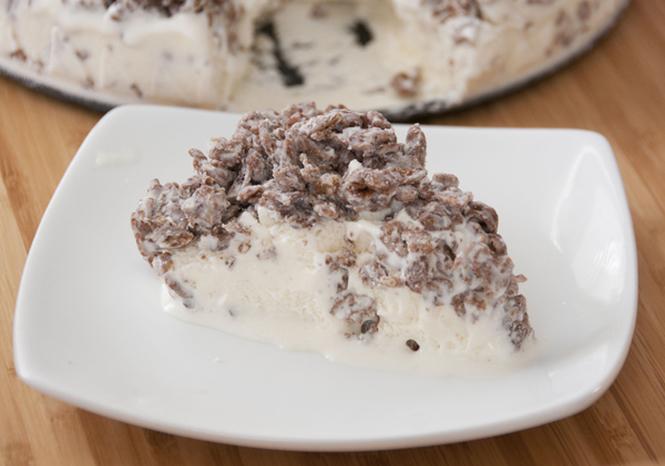 Cocoa Pebbles Ice Cream Cake is a quick and easy dessert recipe incorporating your favorite kid cereal with vanilla ice cream and melted white chocolate.