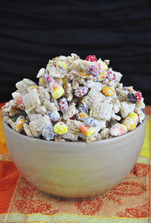 Halloween chex mix: a new twist on party snack mix includes white chocolate, Chex cereal, fall M&M's, candy corn, and pretzel sticks for a Halloween-inspired treat.
