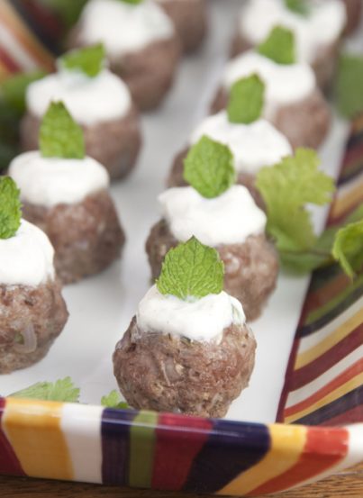 These lamb meatballs are spiced up with cumin, cilantro and mint and served with a traditional Greek yogurt sauce. Makes for a fancy appetizer for a cocktail party.