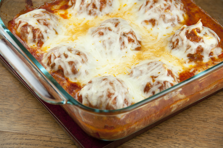 Baked cheese-covered meatballs parmesan with tomato sauce made in the oven. Easy but special enough to serve for a special occasion or dinner guests.