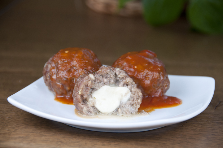 Mozzarella Stuffed Italian Meatballs served with pasta and sauce will be a hit with your family and dinner guests when they discover the hidden pocket of melted cheese inside.