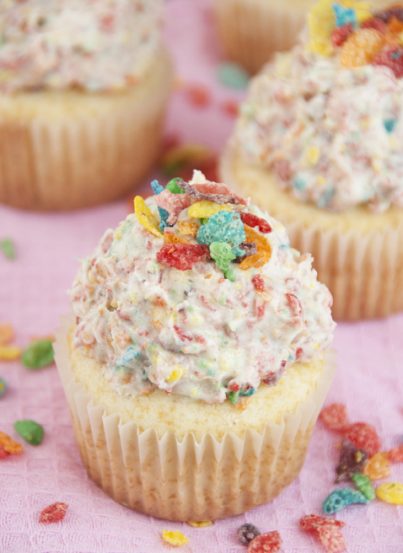 Easy vanilla cupcake recipe topped with Fruity Pebbles Buttercream Frosting perfect for St. Patrick's Day dessert.
