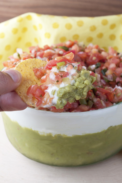 An easy appetizer filled with guacamole, cheese, sour cream, and Pico de Gallo, this Triple Layer Mexican Party Dip is a fun way to enjoy your next Mexican dinner night!