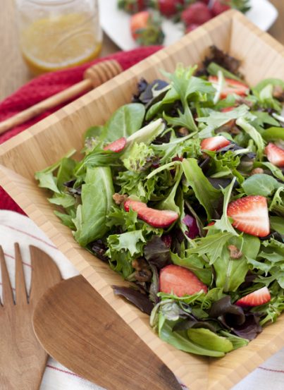 Strawberry Arugula Salad with Honey Lime Vinaigrette recipe is a healthy green salad loaded with fresh fruit and nuts. It is great for picnics and really captures the essence of summer!