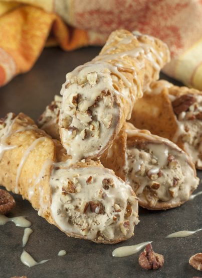 Pumpkin Spice Ice Cream Stuffed Cannoli: espresso ice cream swirled with cream cheese and pumpkin spice stuffed inside tasty cannoli shells and finished off with a sprinkle of pecans and caramel drizzle. This fall and holiday Italian dessert will blow your mind!