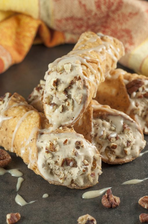 Pumpkin Spice Ice Cream Stuffed Cannoli: espresso ice cream swirled with cream cheese and pumpkin spice stuffed inside tasty cannoli shells and finished off with a sprinkle of pecans and caramel drizzle. This fall and holiday Italian dessert will blow your mind!