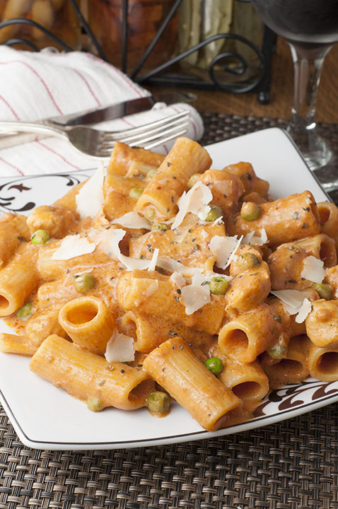 Spicy Chicken Rigatoni recipe is just like my favorite pasta dish at a beloved Italian-American Restaurant. Creamy Alfredo and marinara sauce combine with chicken and peas to make the perfect, easy Italian meal with just the right amount of heat!