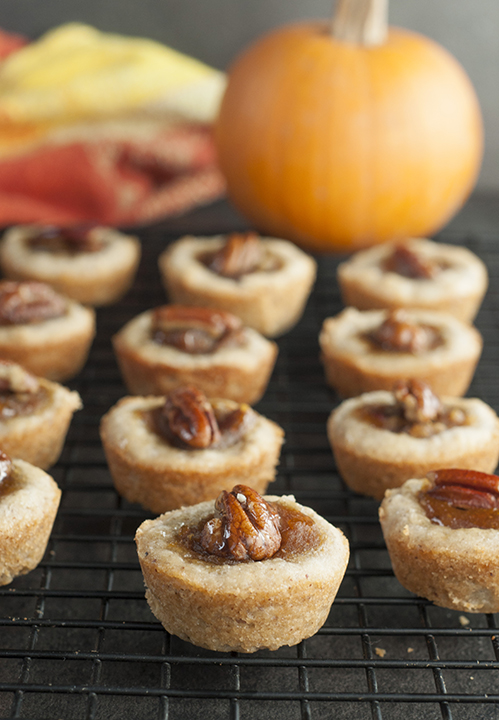Mini Pecan Pumpkin Pies holiday dessert recipe is all that is wonderful about the holidays rolled into one bite size treat! No need to choose between pumpkin pie or pecan pie at your next party!