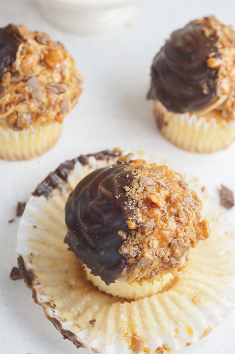 The ultimate soft and fluffy Vanilla Butterfinger Cupcakes are made from scratch and loaded with flavor. They are the perfect holiday or birthday dessert recipe for the candy and peanut butter lover in your life!