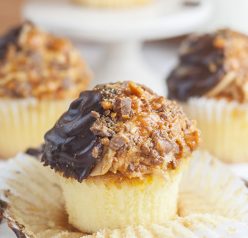 The ultimate soft and fluffy Vanilla Butterfinger Cupcakes are loaded with flavor and the perfect dessert recipe for the candy and peanut butter lover in your life!