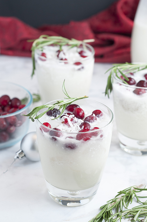 Creamy White Christmas Coconut Margarita Punch recipe for a crowd is so festive will be a huge hit for any holiday party. Garnished with fresh rosemary and cranberries, it is truly Christmas in a glass!