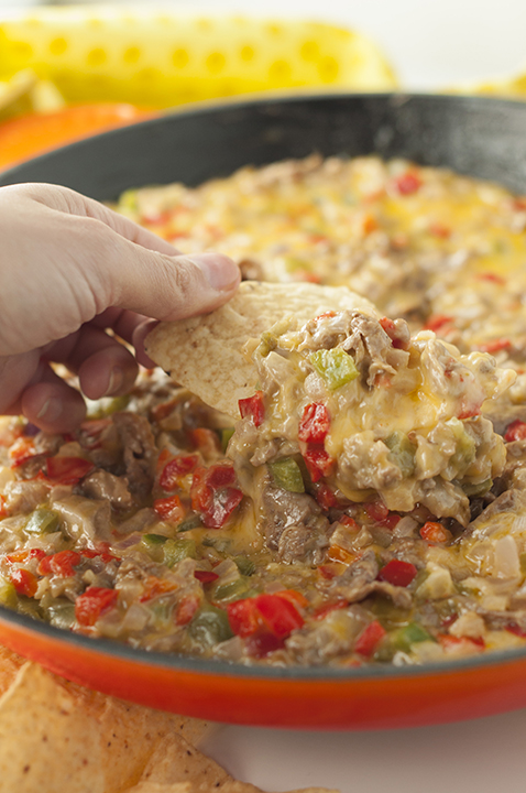 Philly Cheesesteak Dip recipe is made up of tender beef, colorful peppers, and loads of ooey gooey cheese. Perfect for game day, holidays or an appetizer to serve at a party!