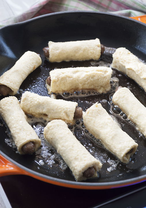 Cooking the breakfast sausage in the cast iron skillet to brown the french toast batter.