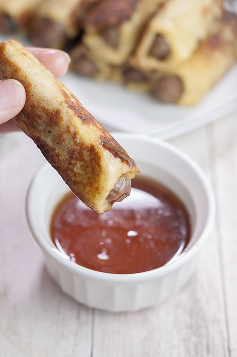 This sweet and savory recipe for Mini French Toast Sausage Roll-Ups served with warm maple syrup for dunking will be the best addition to your next holiday breakfast or brunch!