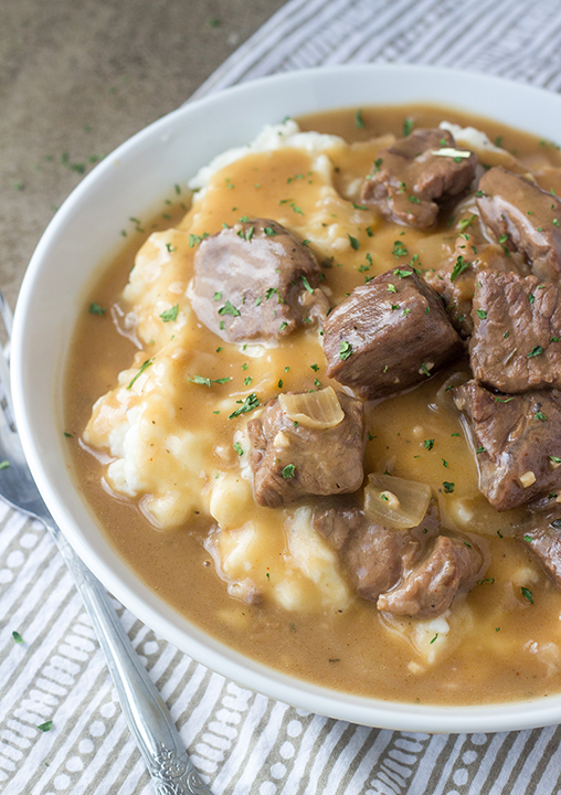 Slow Cooker Beef Tips and Gravy is perfect to serve to dinner guests but simple enough for a weeknight dinner recipe (such as New Year's Eve supper)! Serve it over noodles, potatoes or rice!