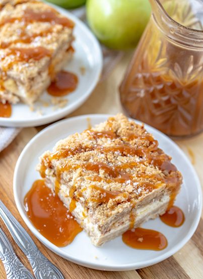 Salted Caramel Apple Cheesecake Bars is a great fall baking recipe with a shortbread crust, cheesecake filling, and an irresistible streusel topping. The salted caramel drizzle makes these the perfect fall dessert for Thanksgiving or Christmas!