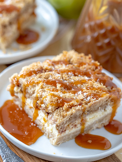 Easy Salted Caramel Apple Cheesecake Bars is a great fall baking recipe with a shortbread crust, cheesecake filling, and an irresistible streusel topping. The salted caramel drizzle makes these the perfect fall dessert for Thanksgiving dessert or Christmas dessert!