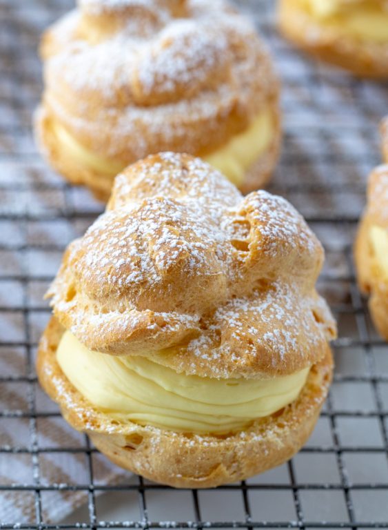 My famous authentic Homemade Cream Puffs recipe: light and airy cream puffs filled with vanilla pudding cream are always a hit with family and anyone I've served them to. If you want an impressive, pretty dessert for Christmas or any holiday, this one is it!