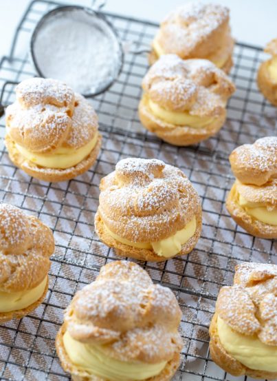 My famous Homemade Cream Puffs recipe: light and airy cream puffs filled with vanilla pudding cream are always a hit with family and anyone I've served them to. If you want an impressive, pretty dessert for Christmas or any holiday, this one is it!