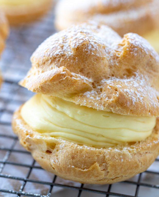 My famous easy, authentic Homemade Cream Puffs recipe: light and airy cream puffs filled with vanilla pudding cream are always a hit with family and anyone I've served them to. If you want an impressive, pretty dessert for Christmas, Easter, or any holiday, this one is it!