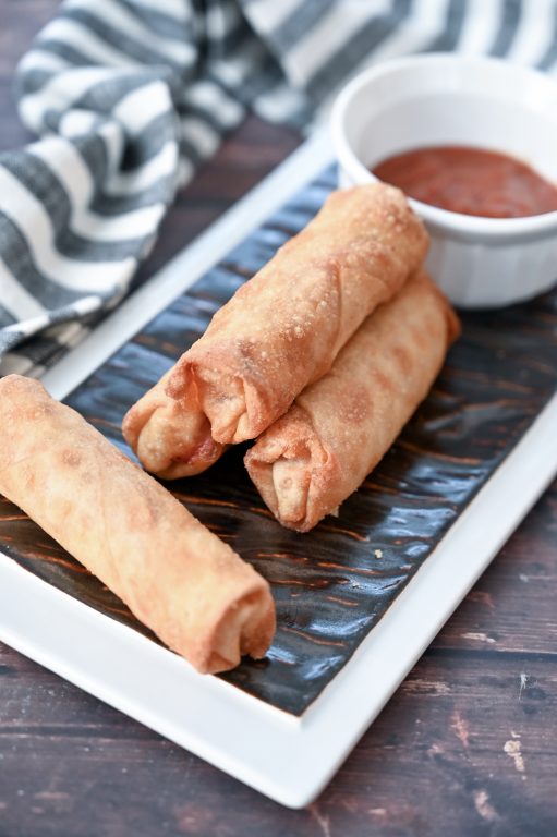 Easy Crowd-Pleasing Baked Pepperoni Pizza Rolls appetizer recipe using egg roll wrappers is my version of the store-bought pizza rolls or pizza logs you find at diners or fast food places. These pizza logs are baked, not fried, so are healthier!