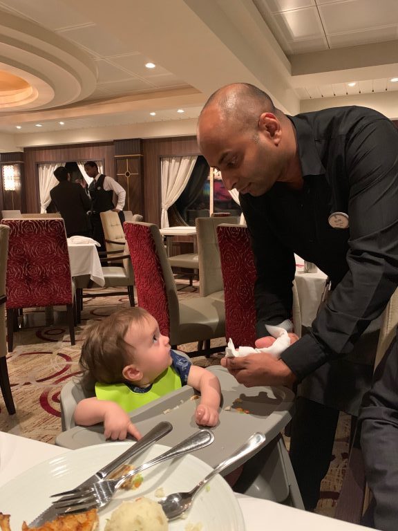 Fun waitstaff with the baby at the main dining room on board Royal Caribbean Symphony of the Seas cruise. 