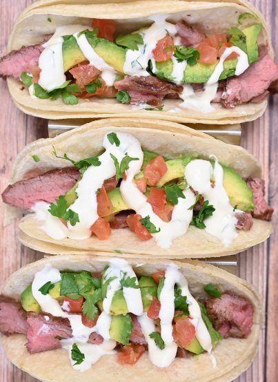 Medium-rare Grilled Flank Steak Tacos with Avocado and Cilantro Lime Crema is easy to prepare during a weeknight or on weekends! This grilled beef recipe with a Mexican twist is wonderful for beginners and experts alike.