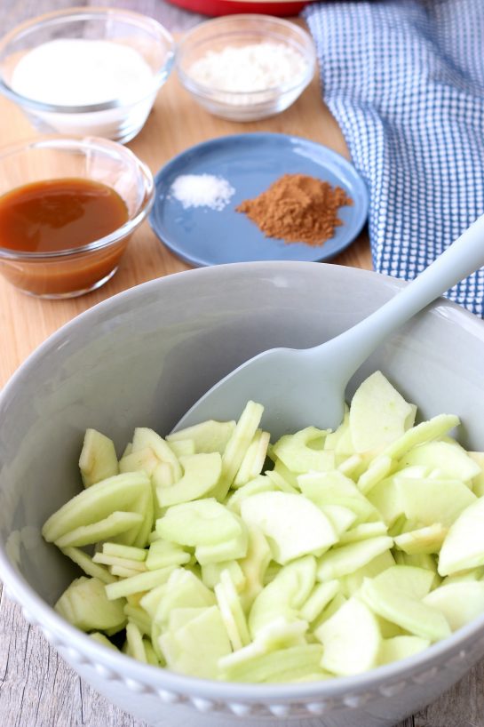 We see the fresh sliced apples in a bowl ready to be made into a delicious caramel apple pie.