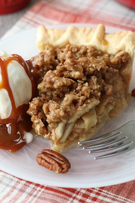 A close up view of the slice of caramel apple pie with ice cream and caramel drizzle.