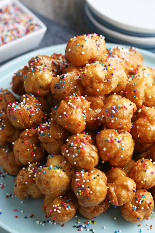 The struffoli when finished looks great on a pile with sprinkles ready to be enjoyed.