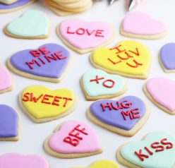 This image shows the Valentines cookies in various states of decoration, some are finished, others need writing and frosting!