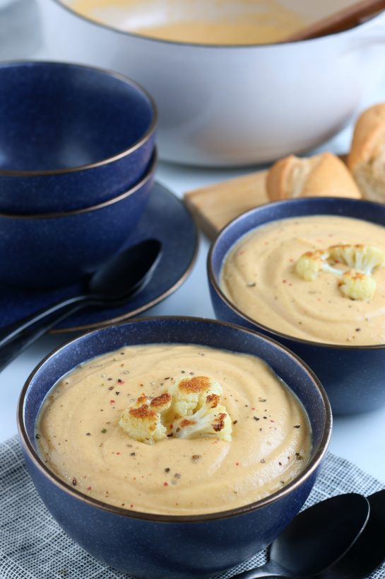 A closer view of the finished cauliflower soup in a dish with roasted cauliflower garnish.