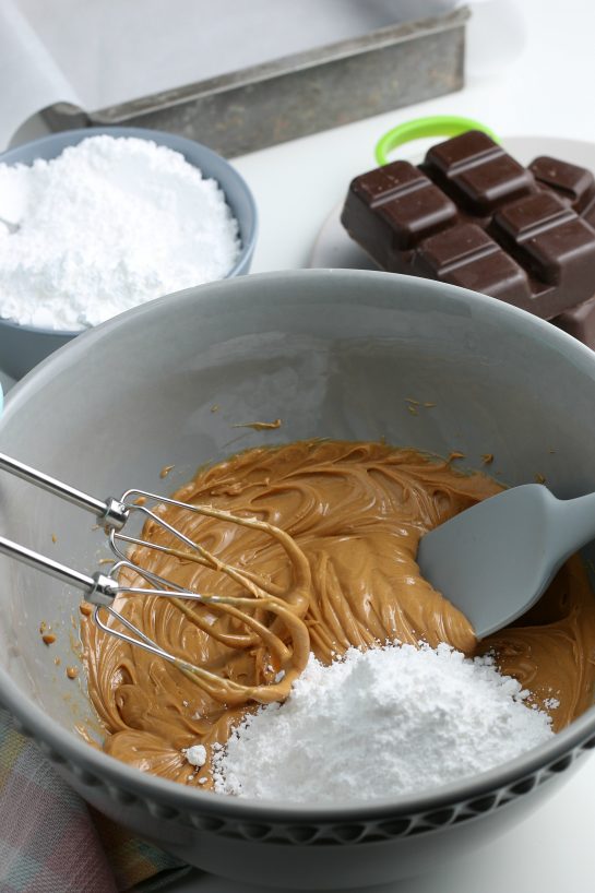 We're slowly adding in the sugar so the batter will thicken up and the middles of our chocolate peanut butter eggs comes together.