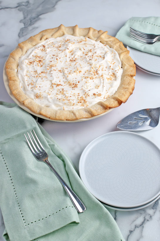 The best coconut cream pie, finished, shown with plates and silverware for serving!