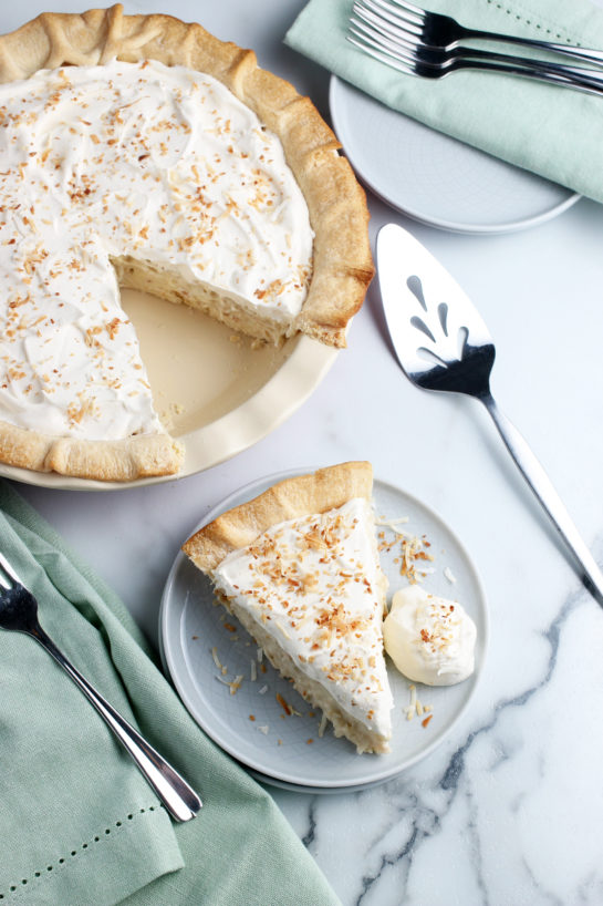 This top down view of the finished pie also shows a slice of pie on a plate ready to be shared or enjoyed.