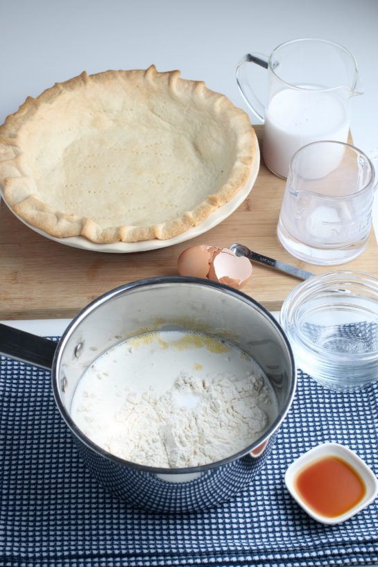 The first part of our recipe is to make the old fashioned coconut cream pie filling. We see the blind baked crust in the background ready to be filled!