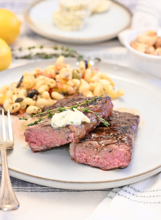 Perfect Grilled Strip Steaks with Herb Compound Butter is a gourmet dinner at home! The compound butter is an easy and flavorful topping to add extra flavor to your steak!