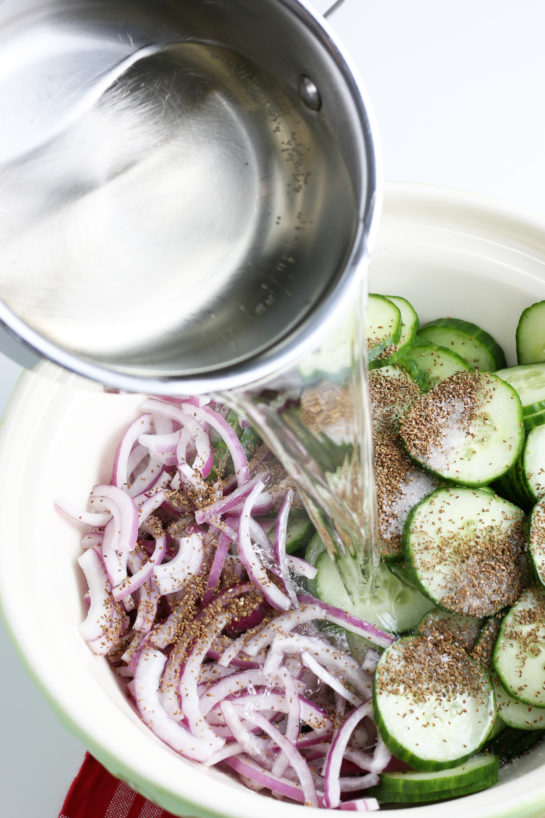 Pouring the dressing onto the cucumber salad