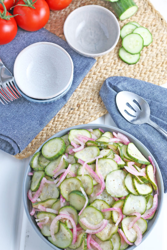 Overheard shot of the finished Cucumber Salad with serving utensils