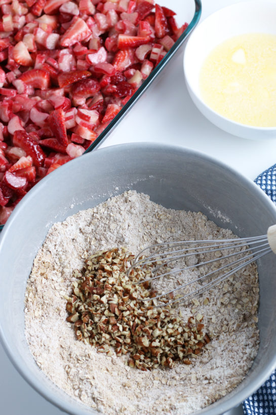 Adding the chopped nuts for Strawberry & Rhubarb crisp recipe
