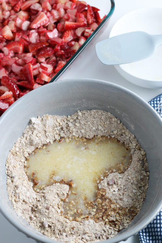 Adding the wet ingredients for Strawberry & Rhubarb crisp dessert recipe